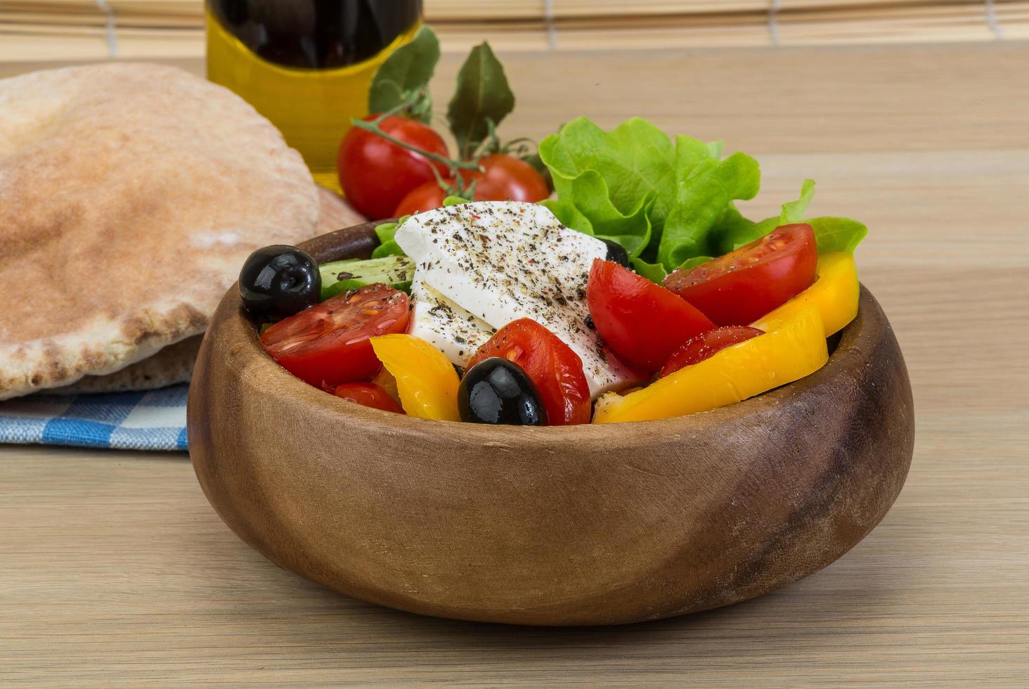 Greek salad in a bowl on wooden background photo