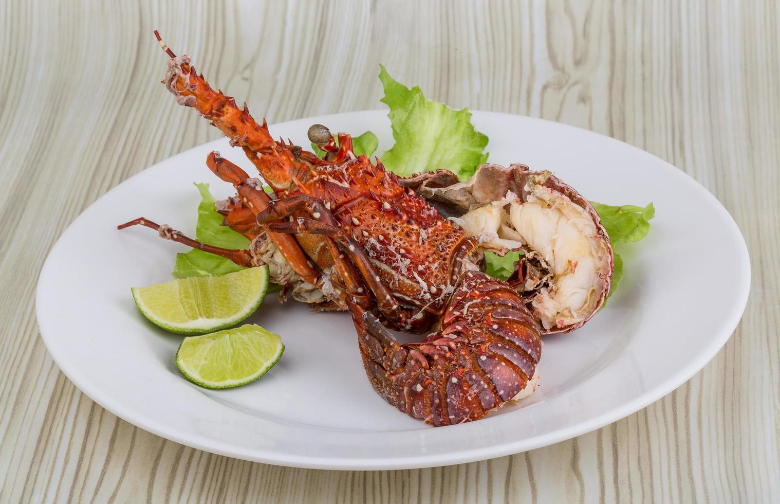 Spiny lobster on the plate and wooden background photo