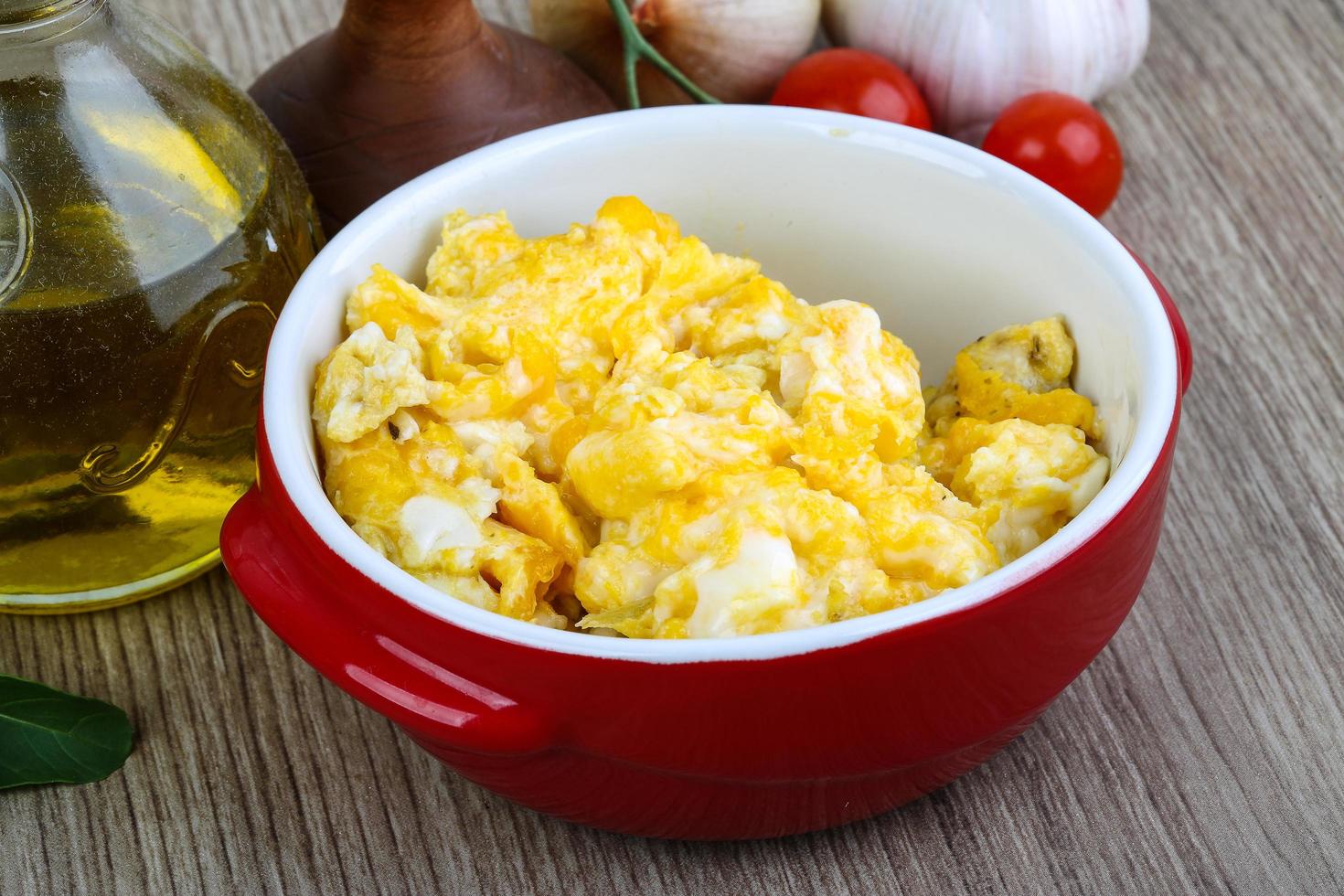 Scrambled eggs in a bowl on wooden background photo