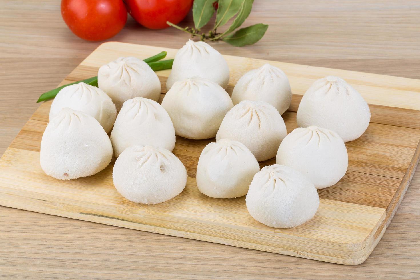 Khinkali on wooden board and wooden background photo