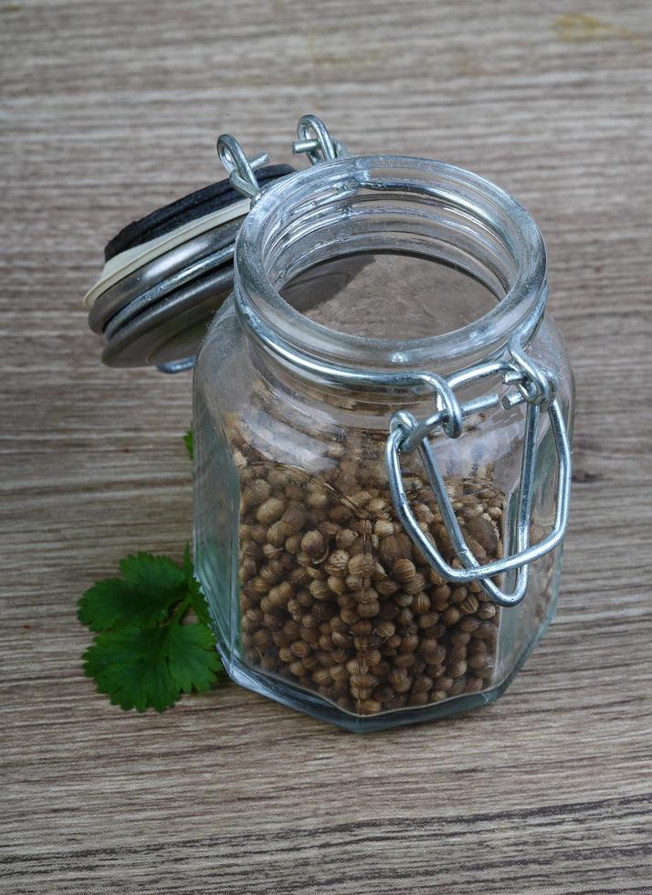 Coriander seeds on wooden background photo