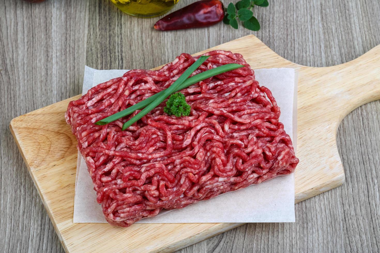 Minced beef on wooden board and wooden background photo