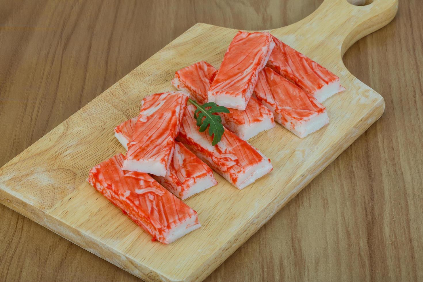 Crab sticks on wooden board and wooden background photo