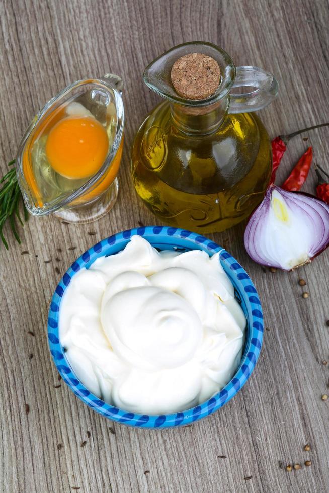 Mayonnaise sauce in a bowl on wooden background photo