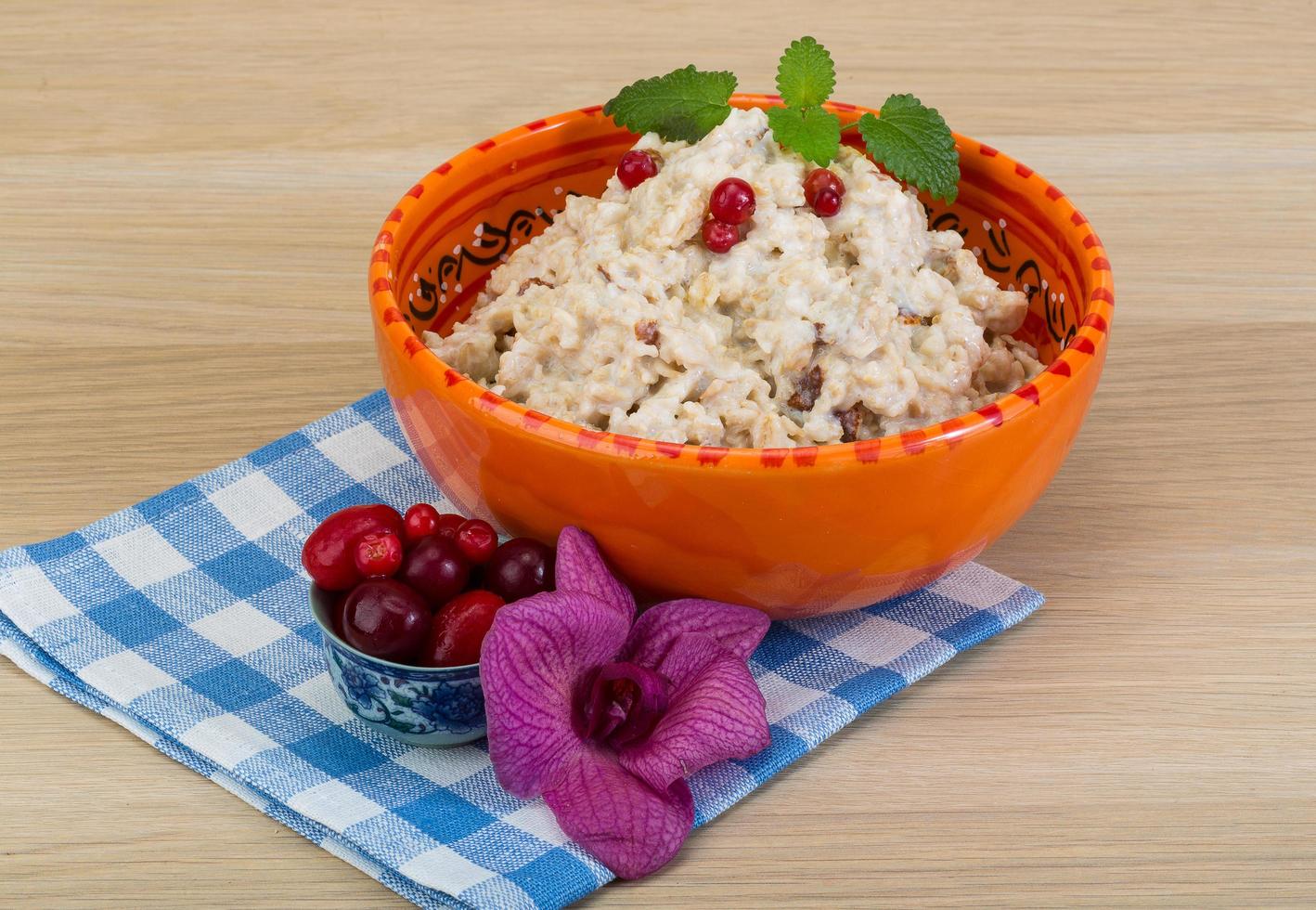 Oatmeal in a bowl on wooden background photo