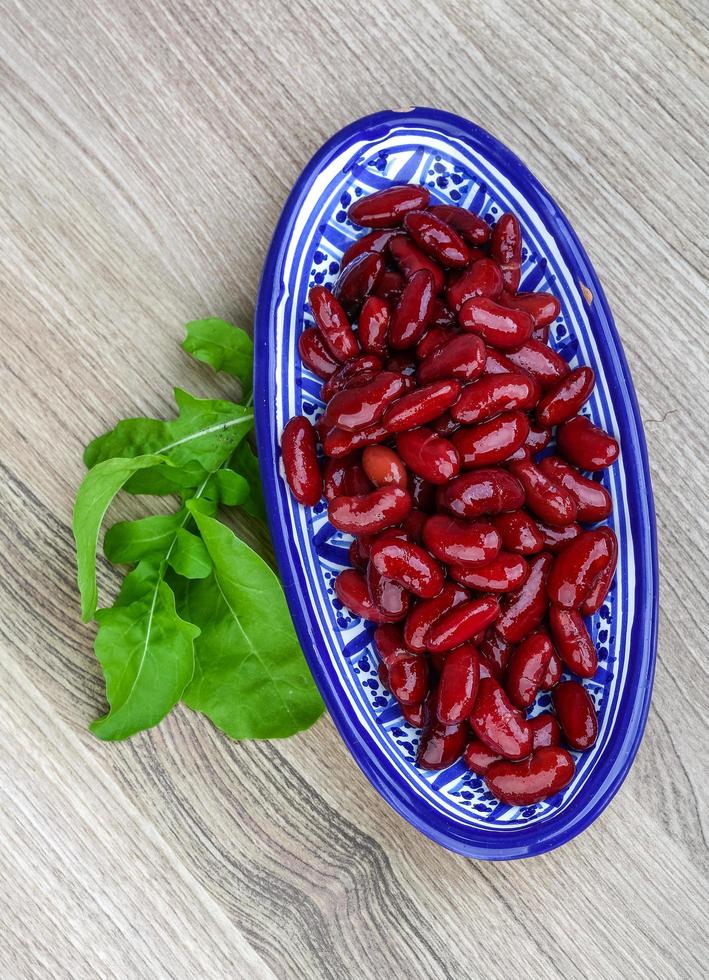 frijoles en un recipiente sobre fondo de madera foto