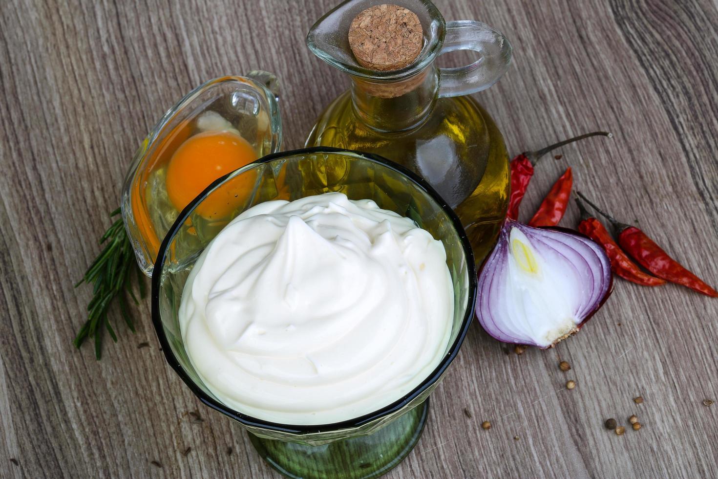 Mayonnaise sauce in a bowl on wooden background photo