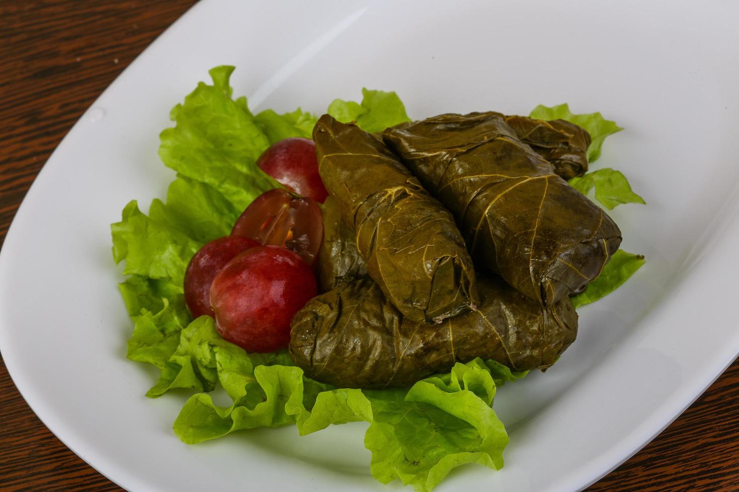 Dolma on the plate and wooden background photo