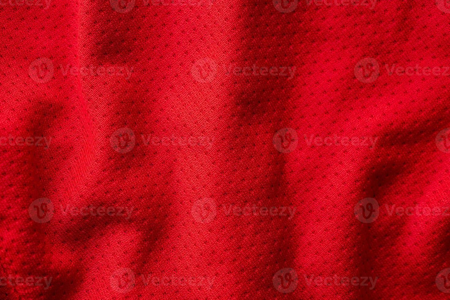 Red fabric sport clothing football jersey with air mesh texture background photo