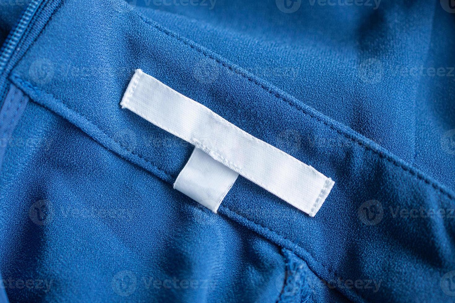 etiqueta de ropa blanca en blanco para el cuidado de la ropa en el vestido azul foto