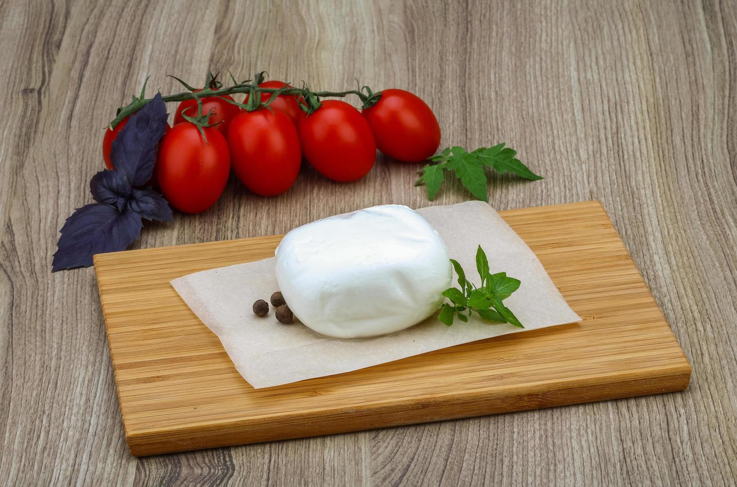 Mozzarella on wooden board and wooden background photo