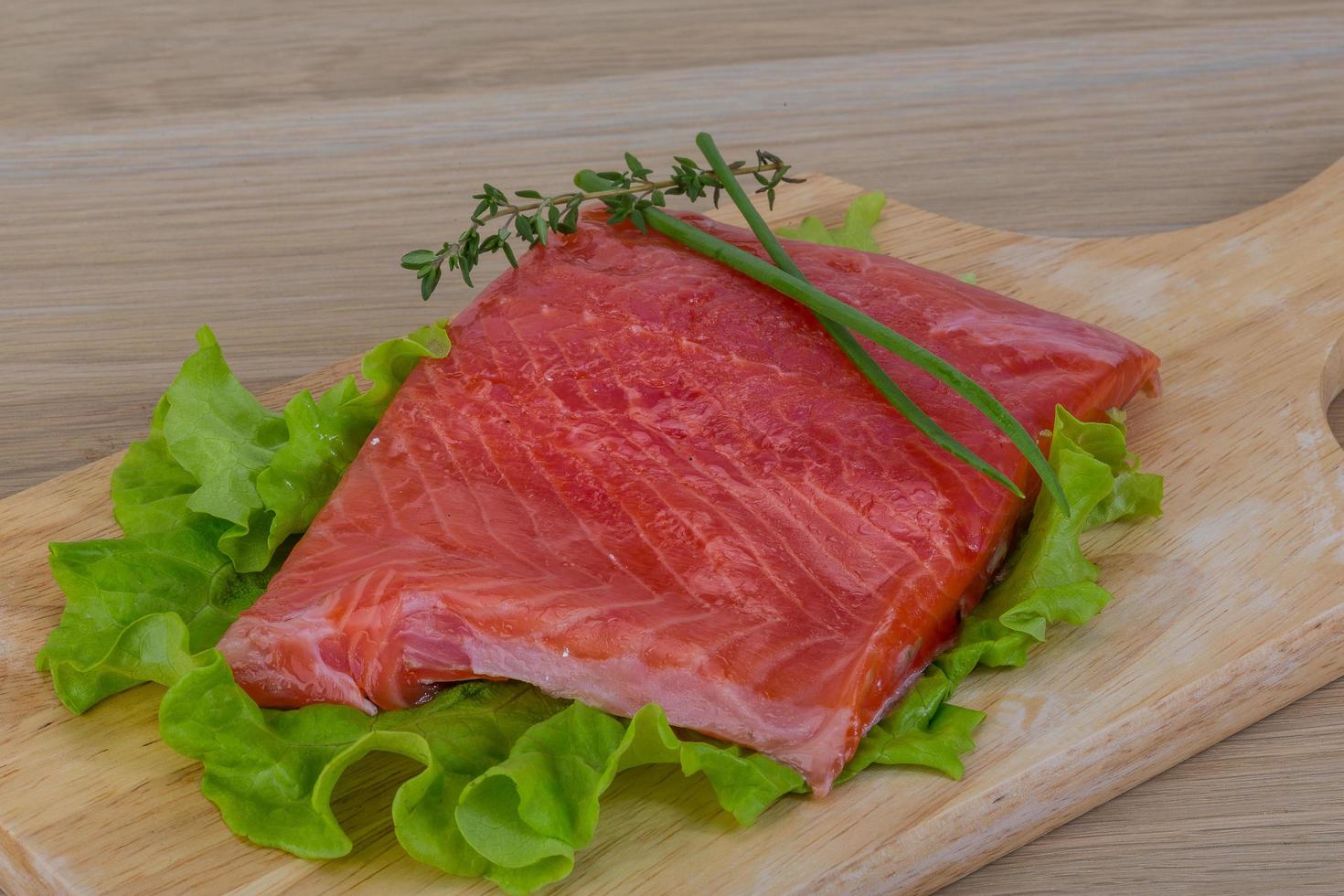 Salmon on wooden board and wooden background photo