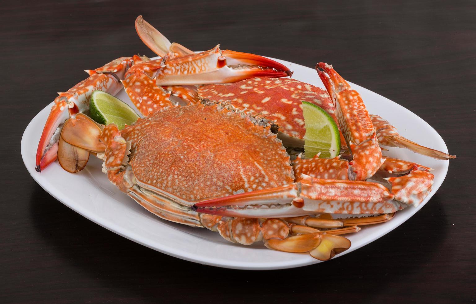 Boiled crabs on the plate and wooden background photo