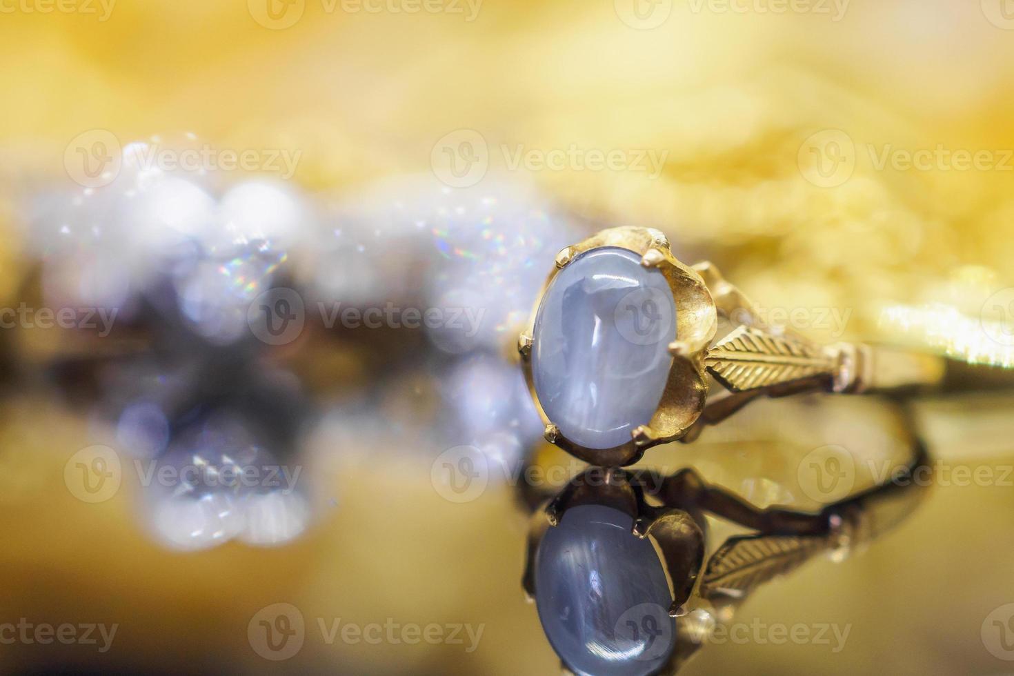 Vintage gold Jewelry blue sapphire rings with reflection on black background photo