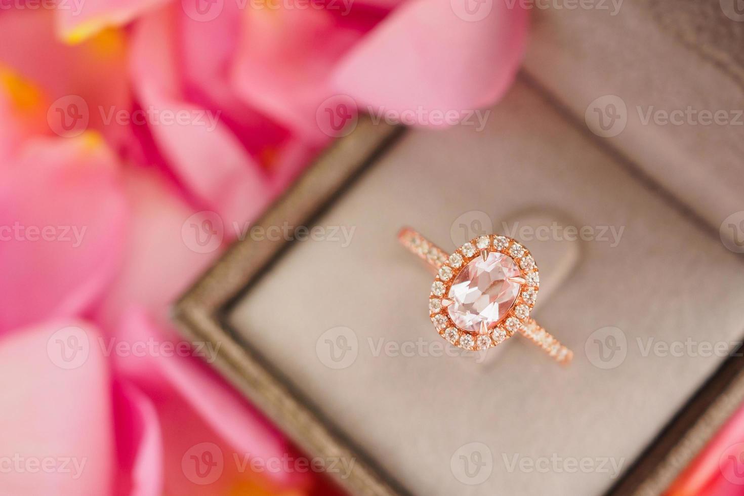 elegant wedding diamond ring in jewelry box on beautiful pink rose petal background close up photo