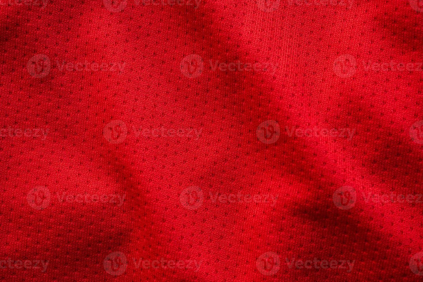 Red fabric sport clothing football jersey with air mesh texture background photo