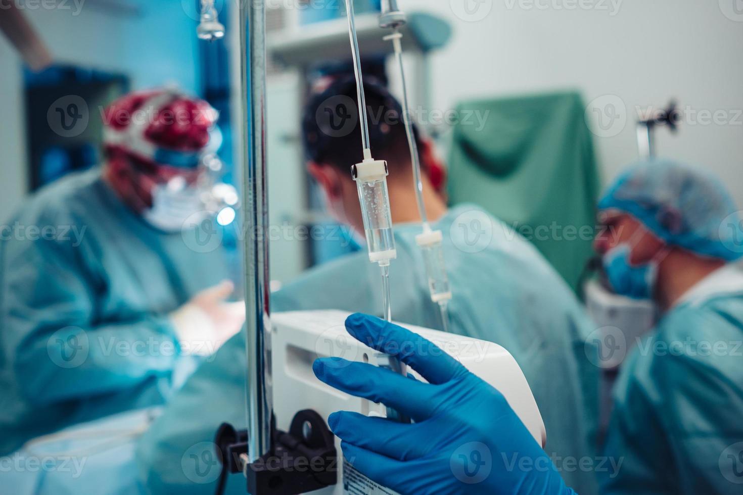 Nurse sets the patient's dropper on the background operation photo