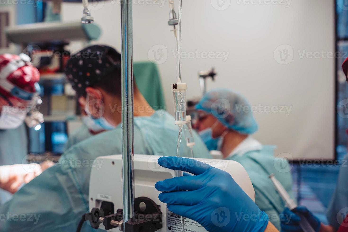 Nurse sets the patient's dropper on the background operation photo