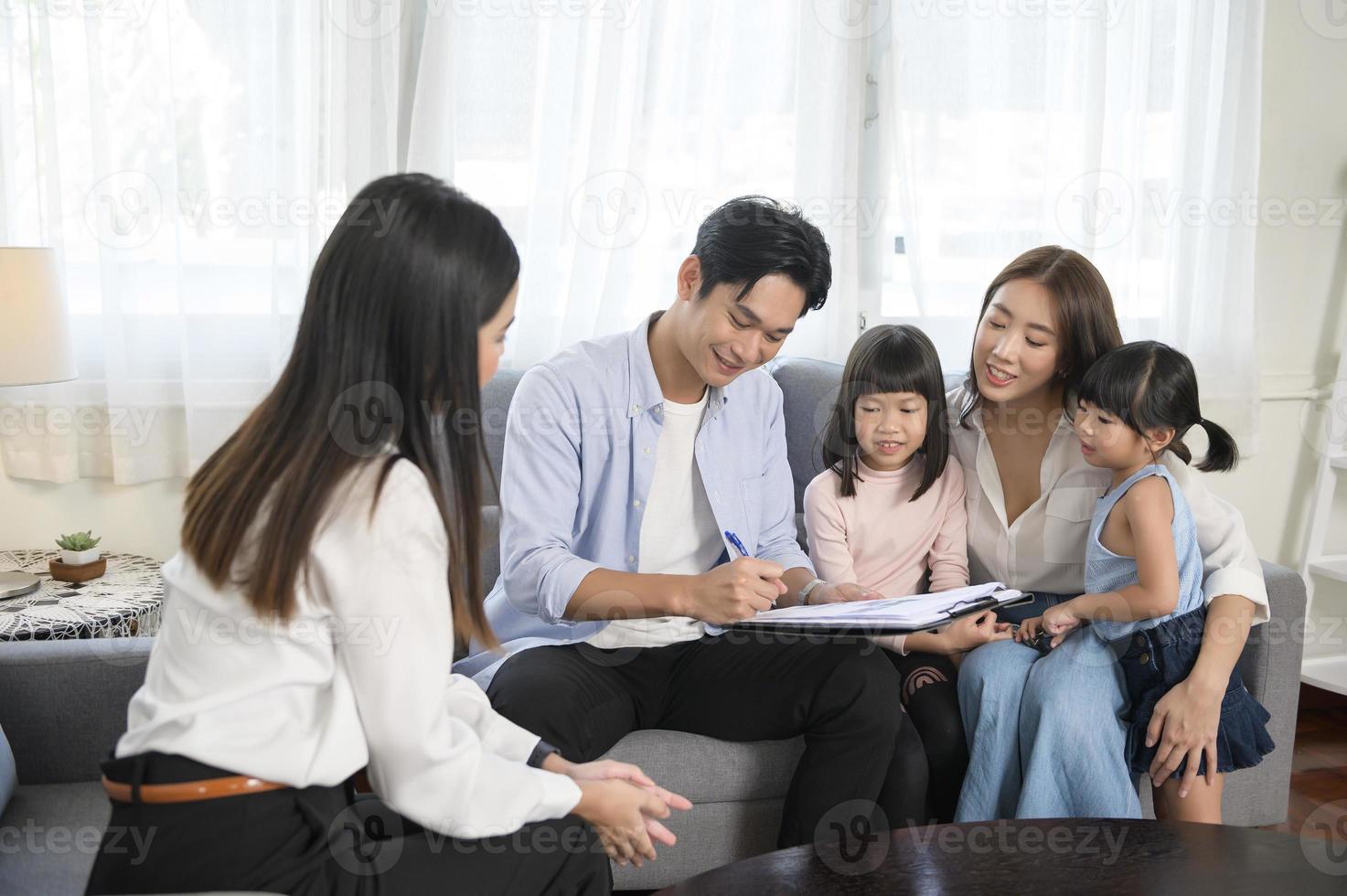 reunión familiar asiática con una agente inmobiliaria o consultora de seguros que ofrece promociones, hipotecas, préstamos, propiedad y concepto de seguro médico. foto