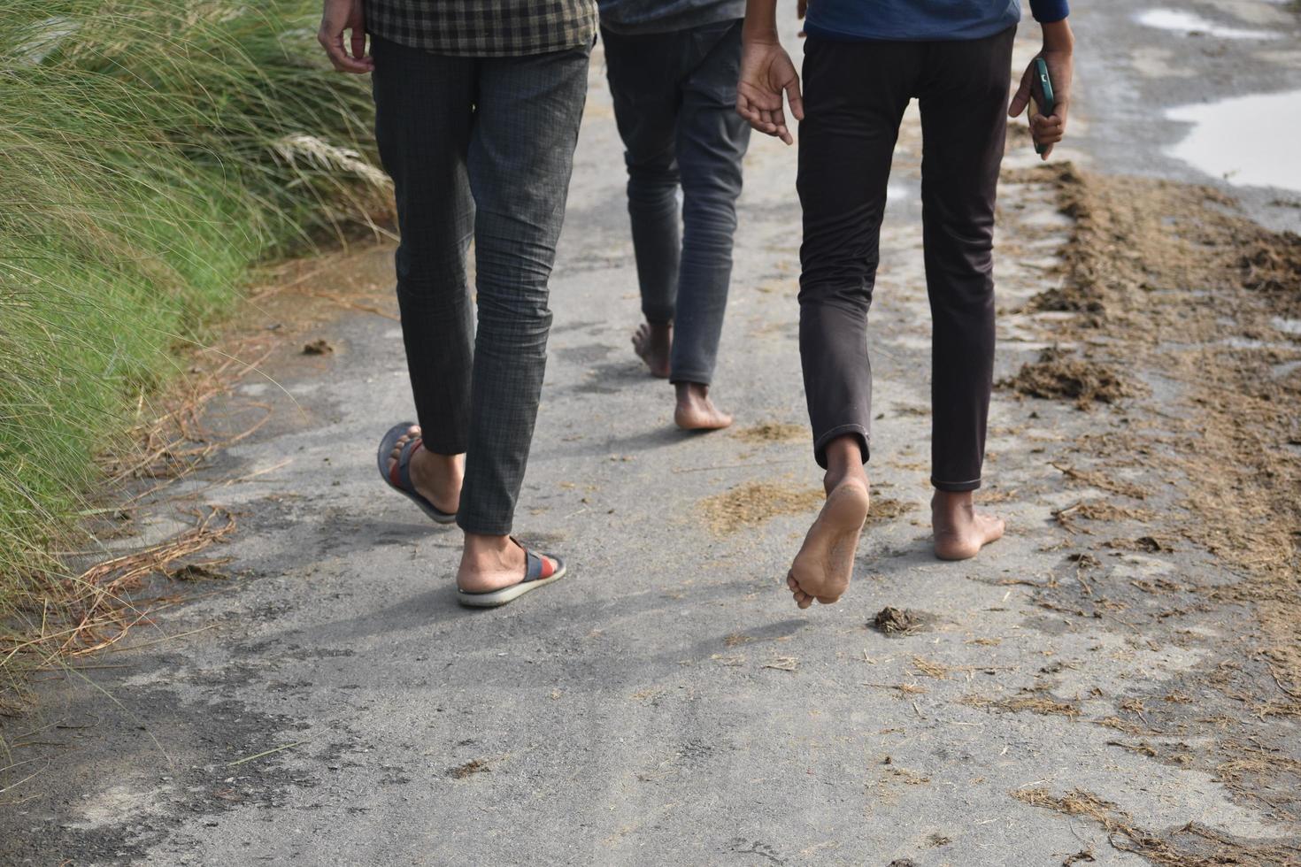 three people walking on road photo