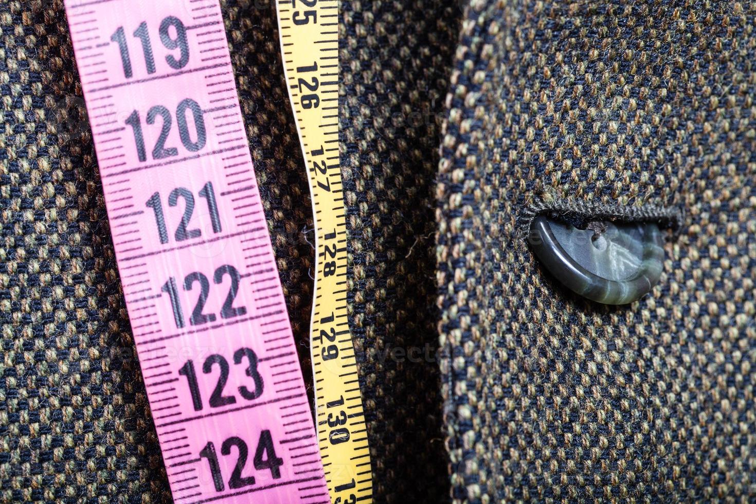 measuring tapes and half buttoned button on jacket photo