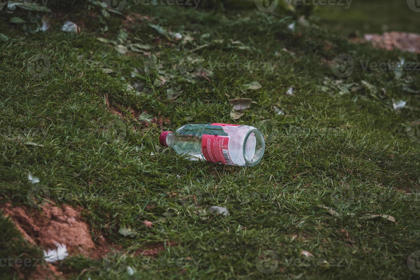 Glass bottle garbage on nature photo