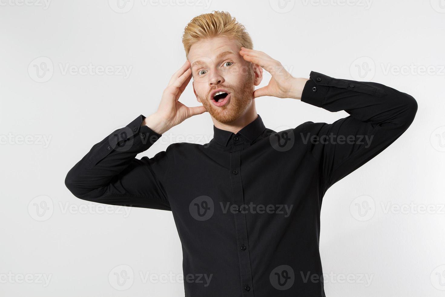 Excited surprised shock young man isolated on gray background. Happy Redhead guy with red beard in black stylish shirt. Success and pass exam concept. Copy space. Close up of Face expression. photo