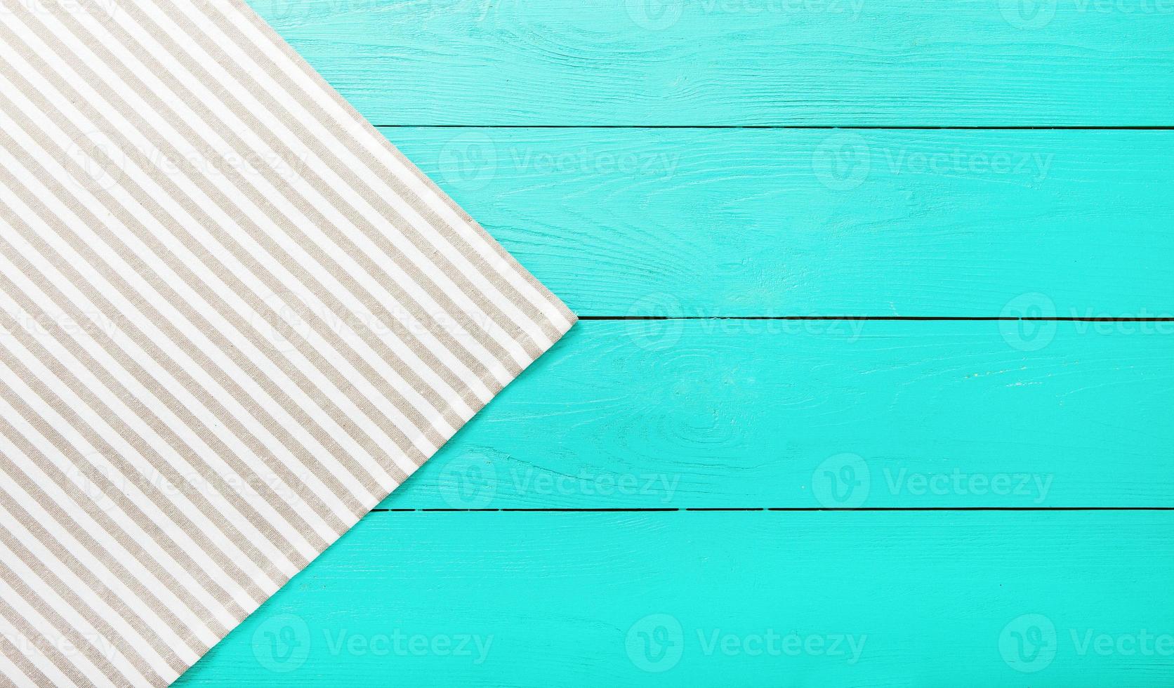 Striped gray and white material on blue wooden background. Top view and copy space. Mock up photo