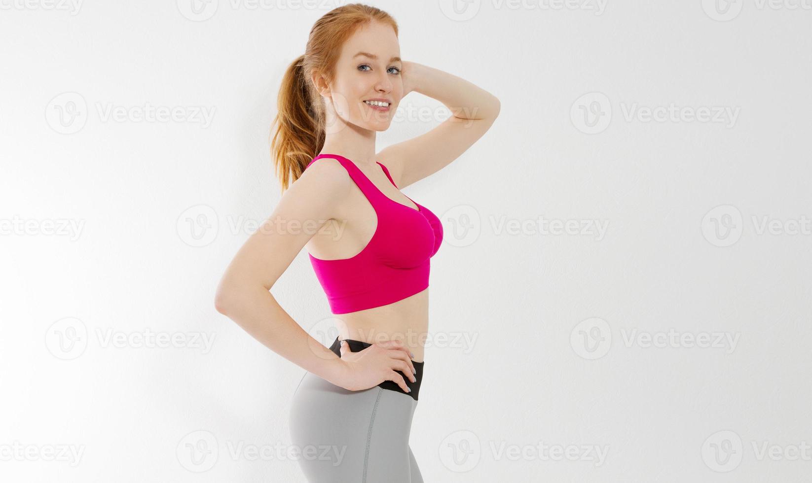 Young red haired girl in sport wear clothes isolated on white background. Slim body figure and healthy lifestyle. Fitness and sports concept. Banner photo