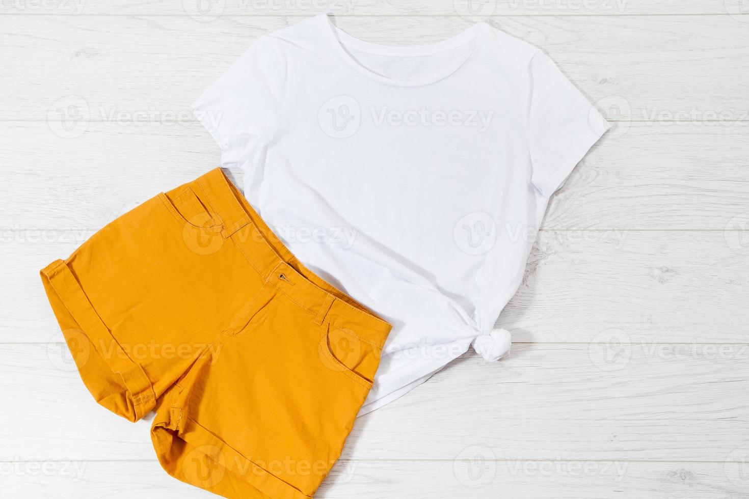 White closeup t shirt mock up flat lay on white wooden background. Top view and copy space. Mockup summer t-shirt and summertime. Template blank shirt. photo
