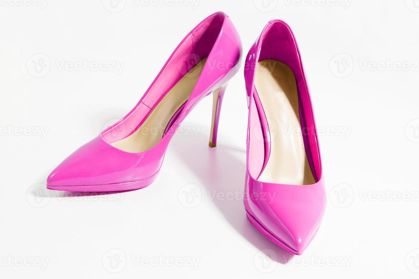 Closeup pink women patent leather shoes isolated on white background. Stilettos shoe type. Summer fashion and shopping concept. Luxury and glamour party ladies wardrobe accessory. Selective focus photo