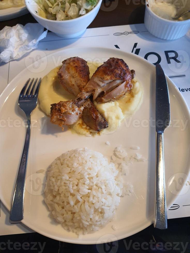 One of the meals served in a small hotel in Turkey. Which consists of butter rice, spicy chicken and mashed potato. photo