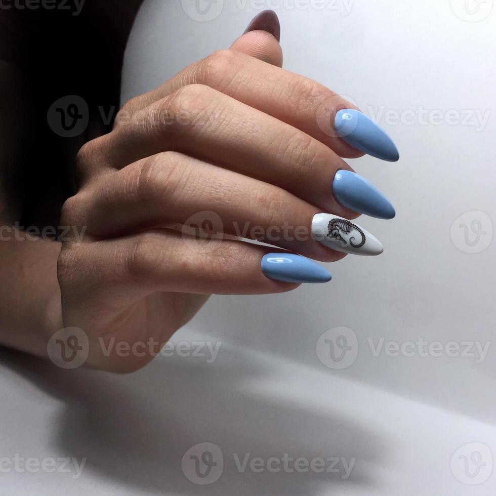 manicura femenina azul en las uñas de cerca foto