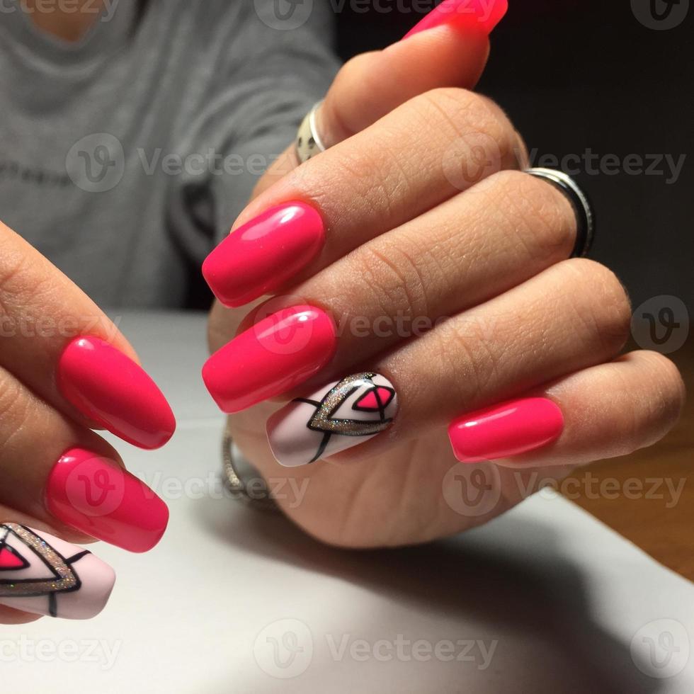 manos femeninas con elegante manicura roja sobre fondo gris foto
