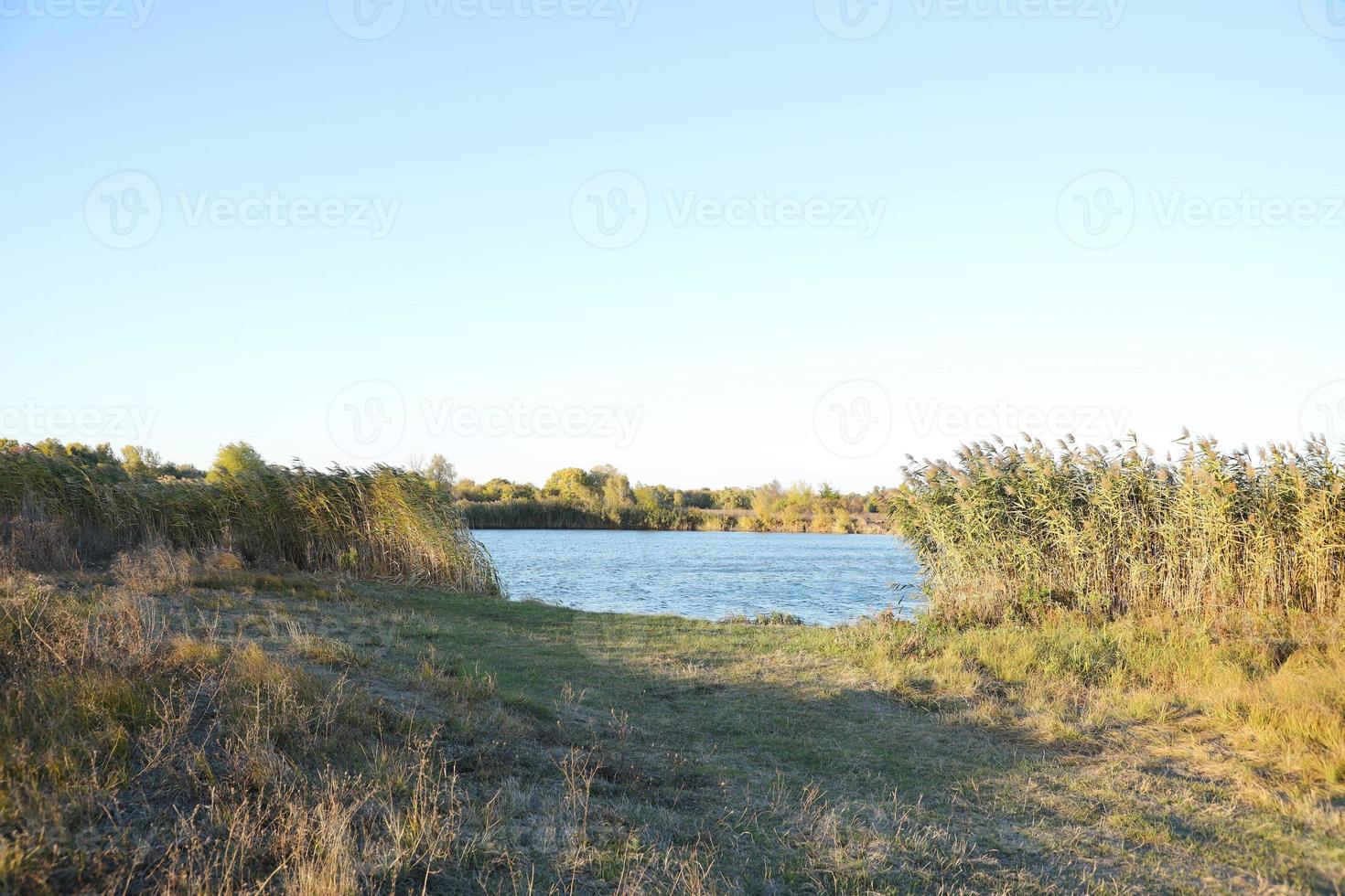 Beautiful autumn landscape with lake and multicoloral trees. Picturesque place with lake and tall trees photo