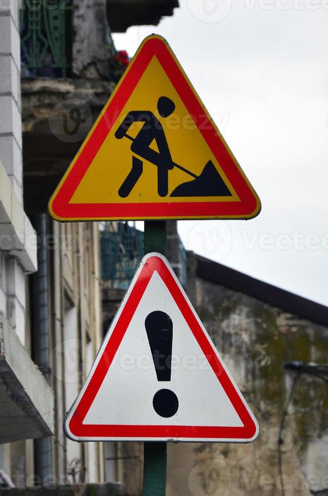 Road signs with an exclamation mark and a man digging the earth. Road works are underway photo