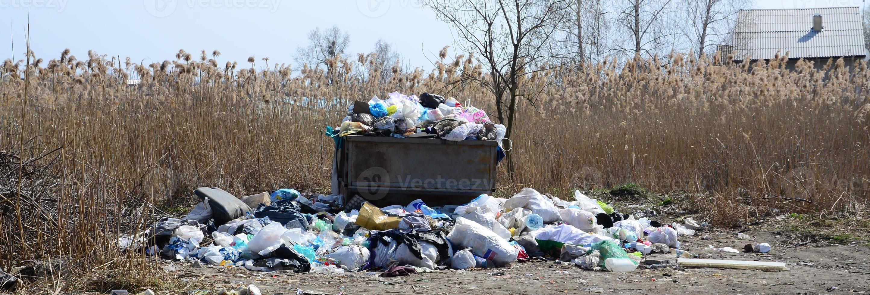 The garbage can is packed with garbage and waste. Untimely removal of garbage in populated areas photo