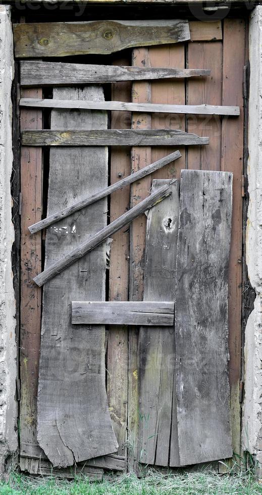 Boarded up wooden door to an old abandoned house photo