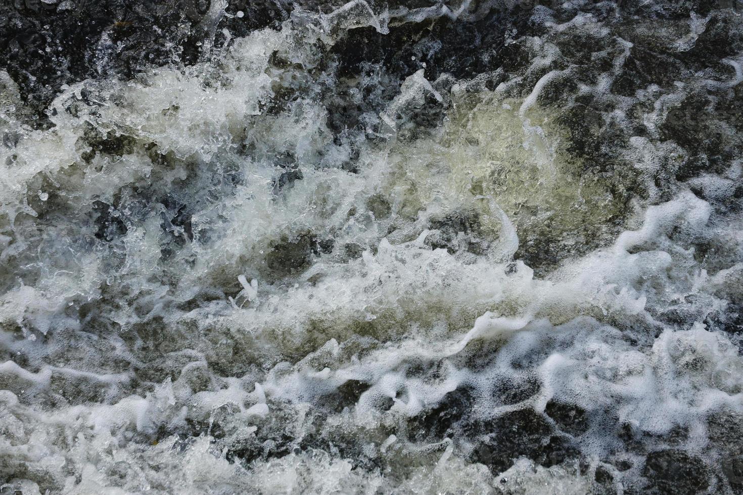 Waves of water of the river and the sea meet each other during high tide and low tide. Deep blue stormy sea water surface with white foam and waves pattern, background photo