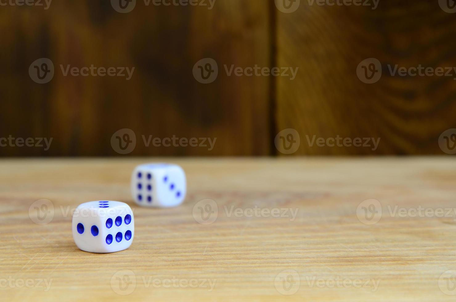 A few dice lies on the surface of natural wood. Items for generating numbers from one to six in the form of points that are painted on the side of cubes. The concept of gambling photo