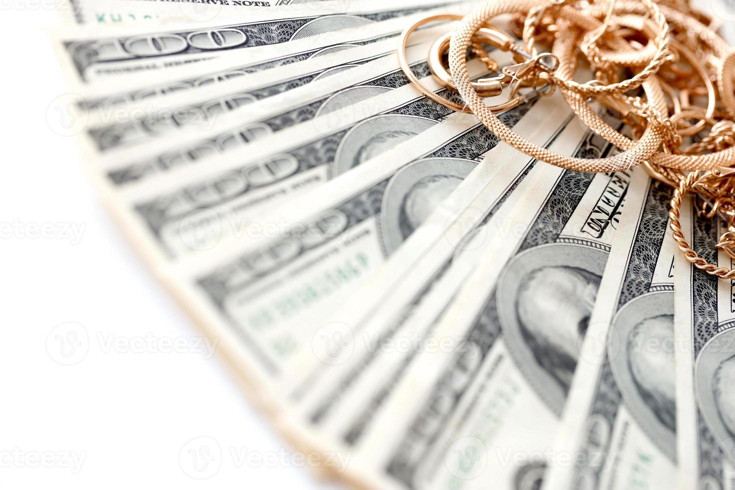 Many expensive golden jewerly rings, earrings and necklaces with big amount of US dollar bills on white background. Pawnshop or jewerly shop photo