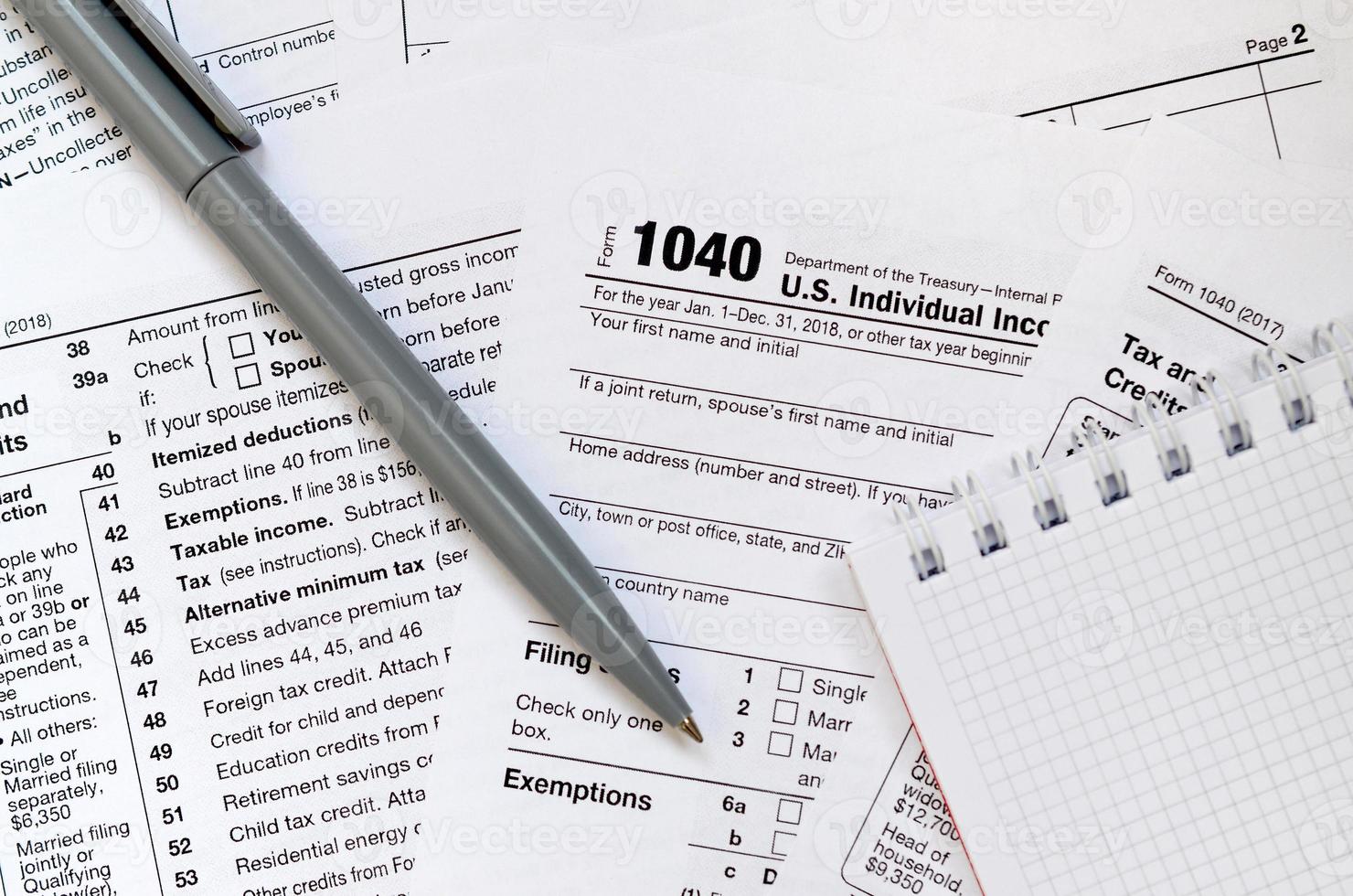 The pen and notebook is lies on the tax form 1040 U.S. Individual Income Tax Return. The time to pay taxes photo