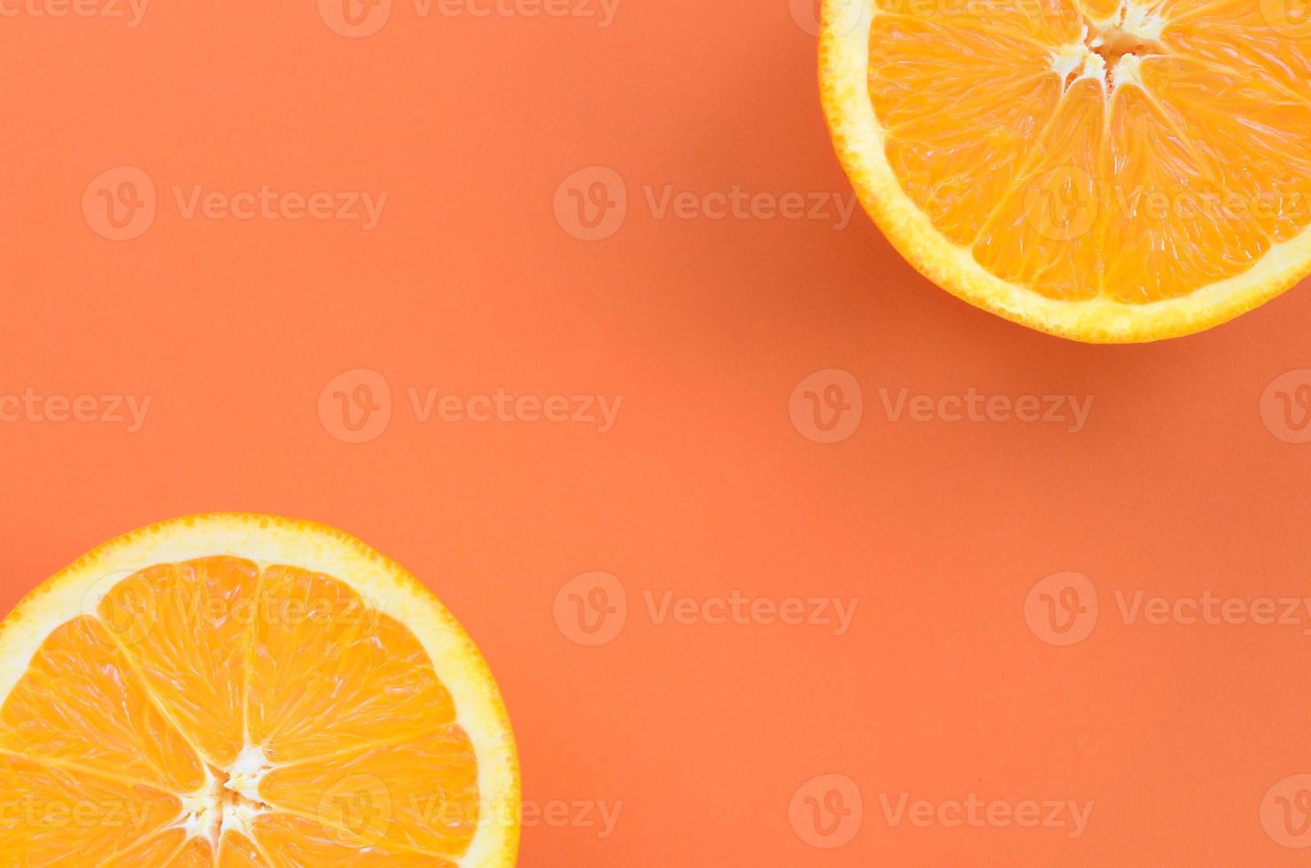Top view of a several orange fruit slices on bright background in orange color. A saturated citrus texture image photo