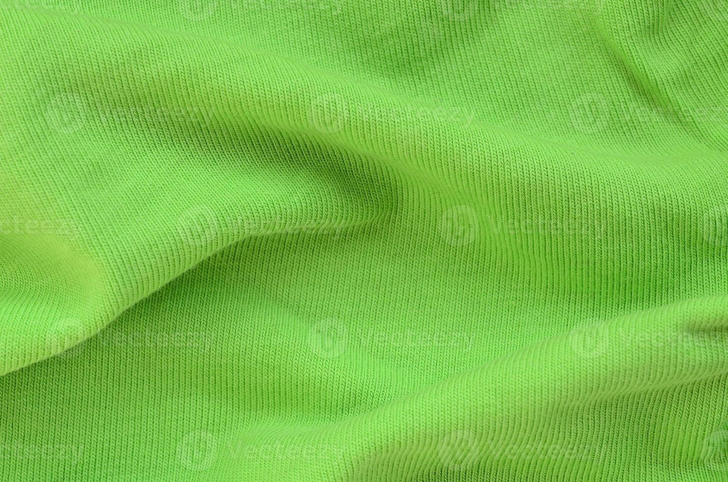 The texture of the fabric is bright green. Material for making shirts and blouses photo