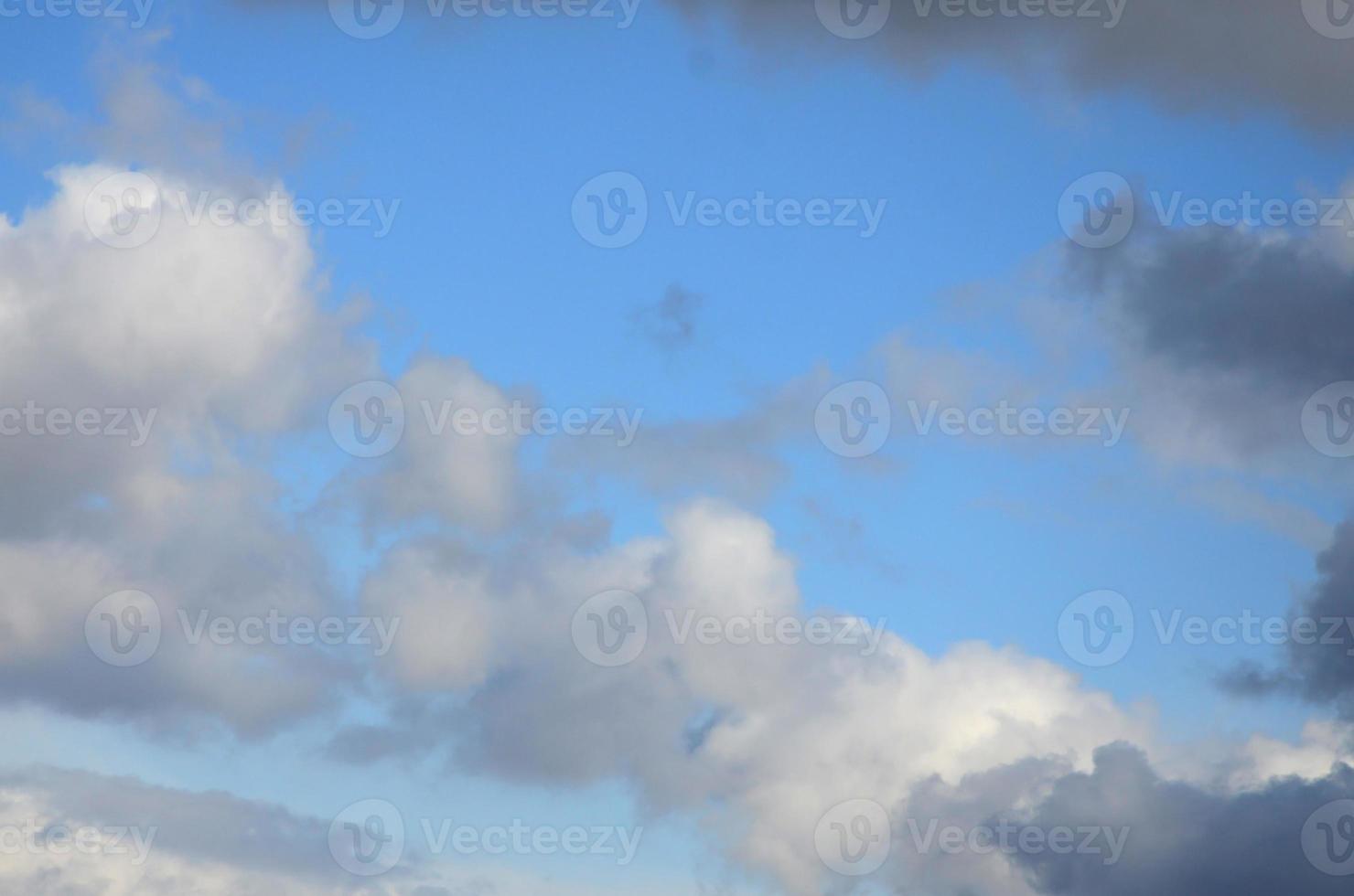 A blue sky with lots of white clouds of different sizes photo