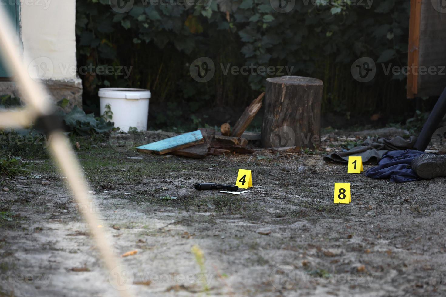 evidencia con marcador csi amarillo para la numeración de evidencia en el patio trasero residencial por la noche. concepto de investigación de la escena del crimen foto