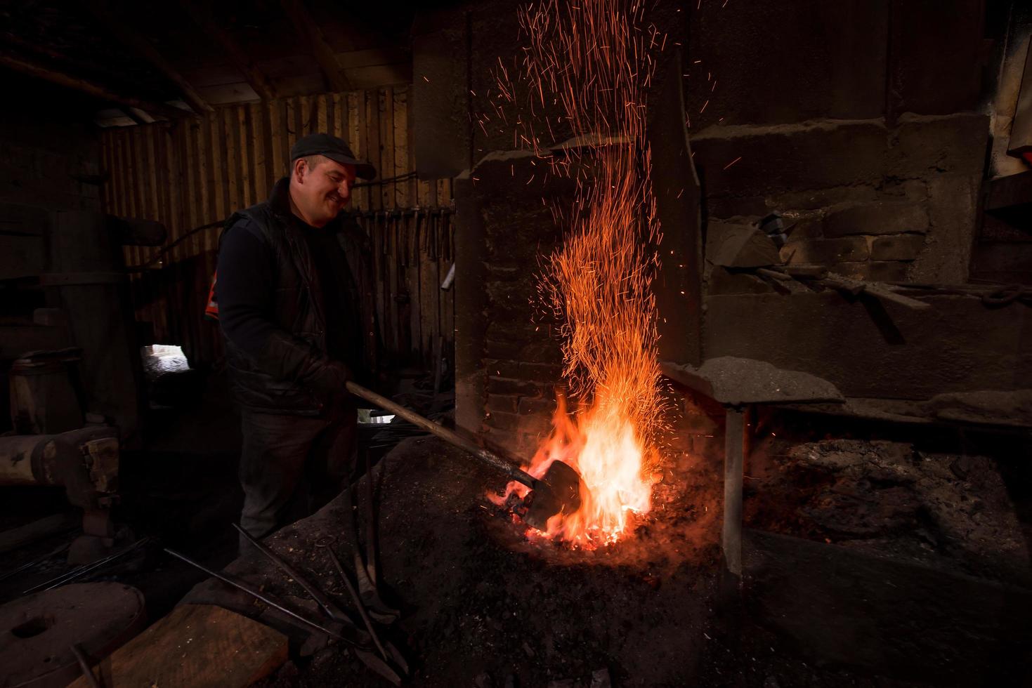 joven herrero tradicional trabajando con fuego abierto foto