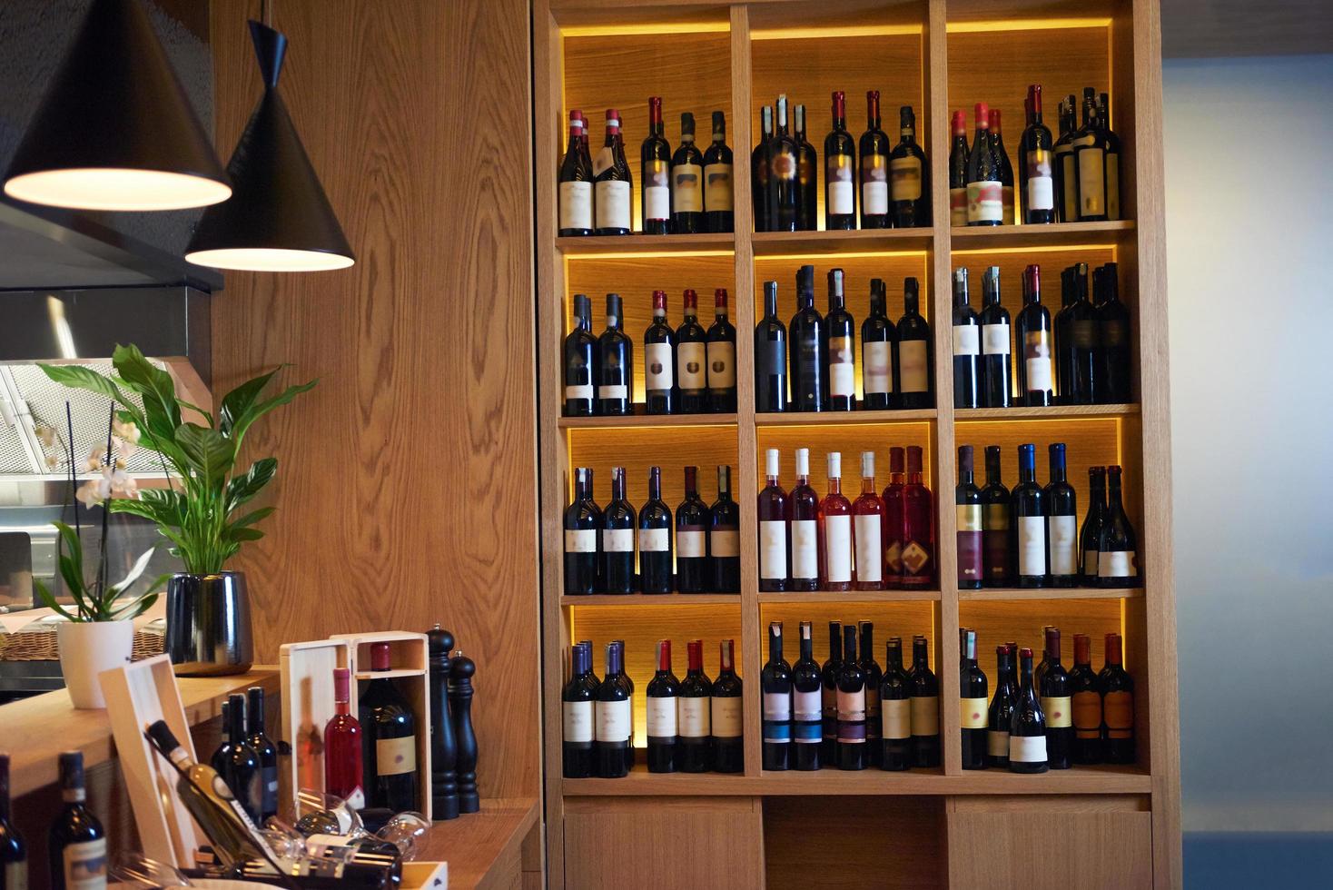 Wine bottles on a wooden shelf. photo