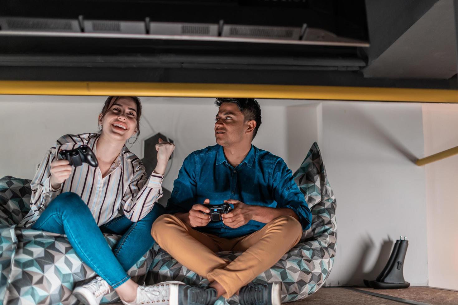 Work hard play hard. Workers Playing computer games man against woman during break in relaxation area at creative startup Office photo