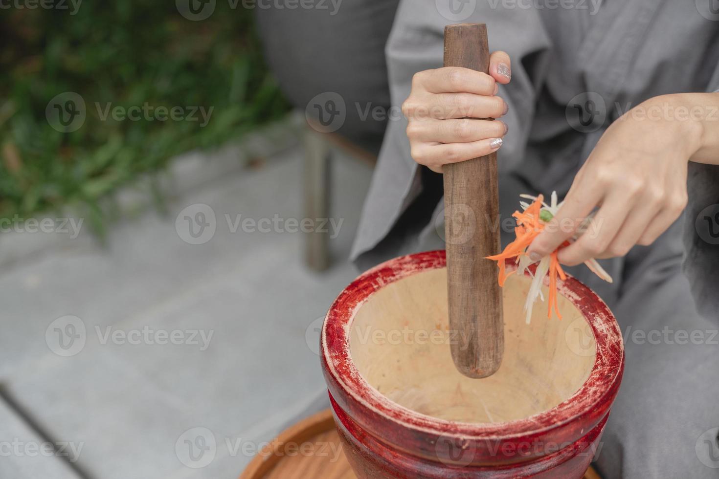 Woman hand making thai food call papaya salad or Som Tam, mixing and pounding in a mortar. photo